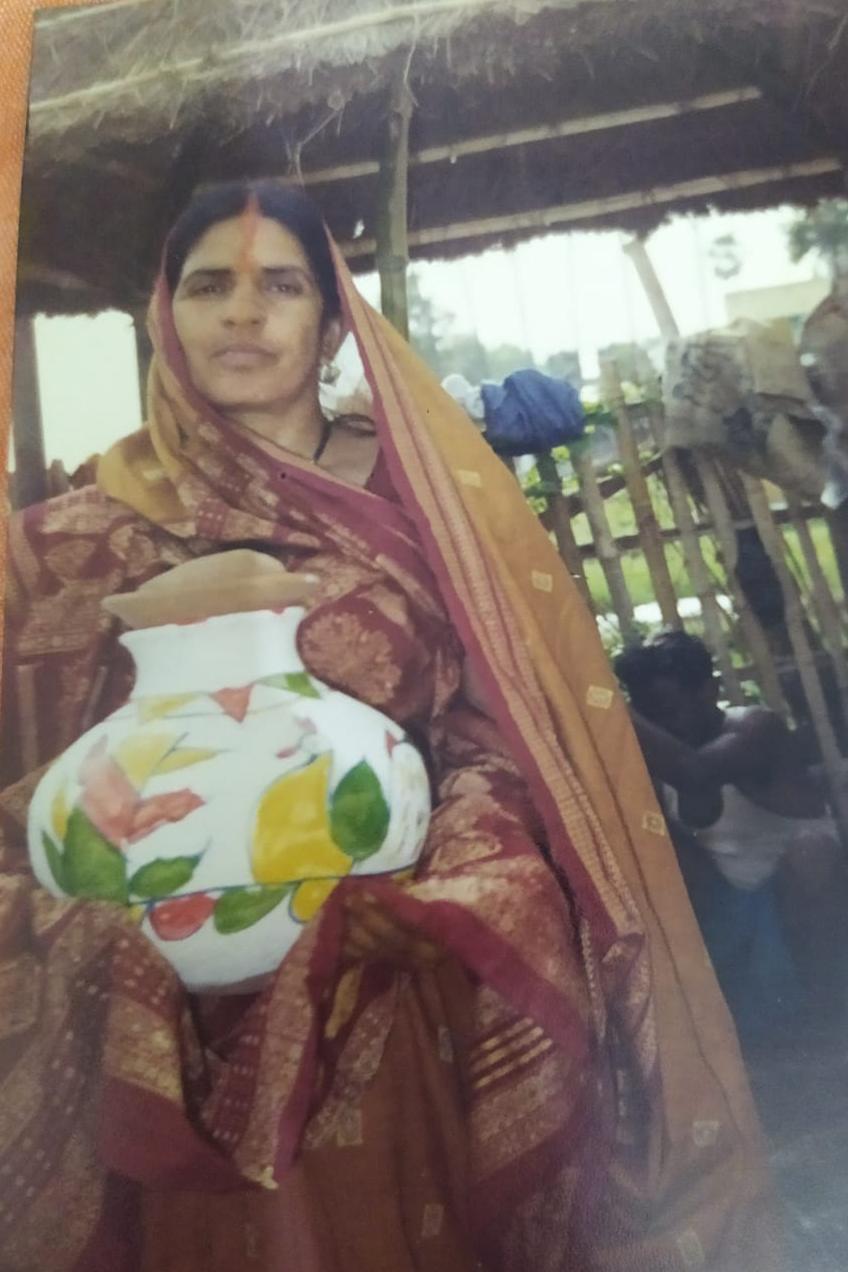 अपनी बेटी के विवाह समारोह में सजा हुआ मिट्टी का घड़ा थामे फुला देवी।