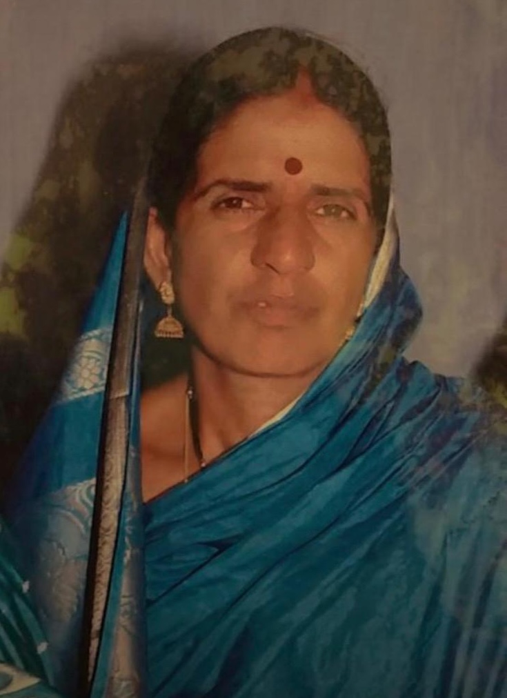 नीली साड़ी पहने फुला देवी कैमरे की ओर देख रही हैं।